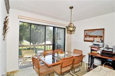 978 Sand Castle Road Sanibel, FL 33957 - Photo 3 of 10 a dining room with furniture a chandelier and wooden floor
