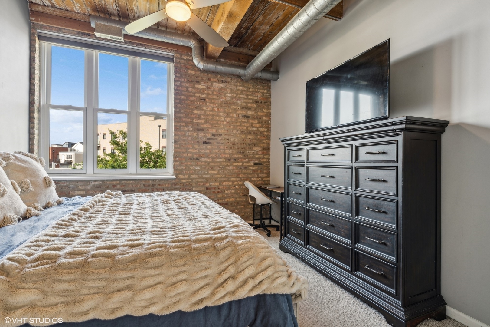 1235 West George Street, Unit 215 Chicago, IL 60657 - Photo 14 of 25 a bedroom with a bed and a flat tv screen on dresser