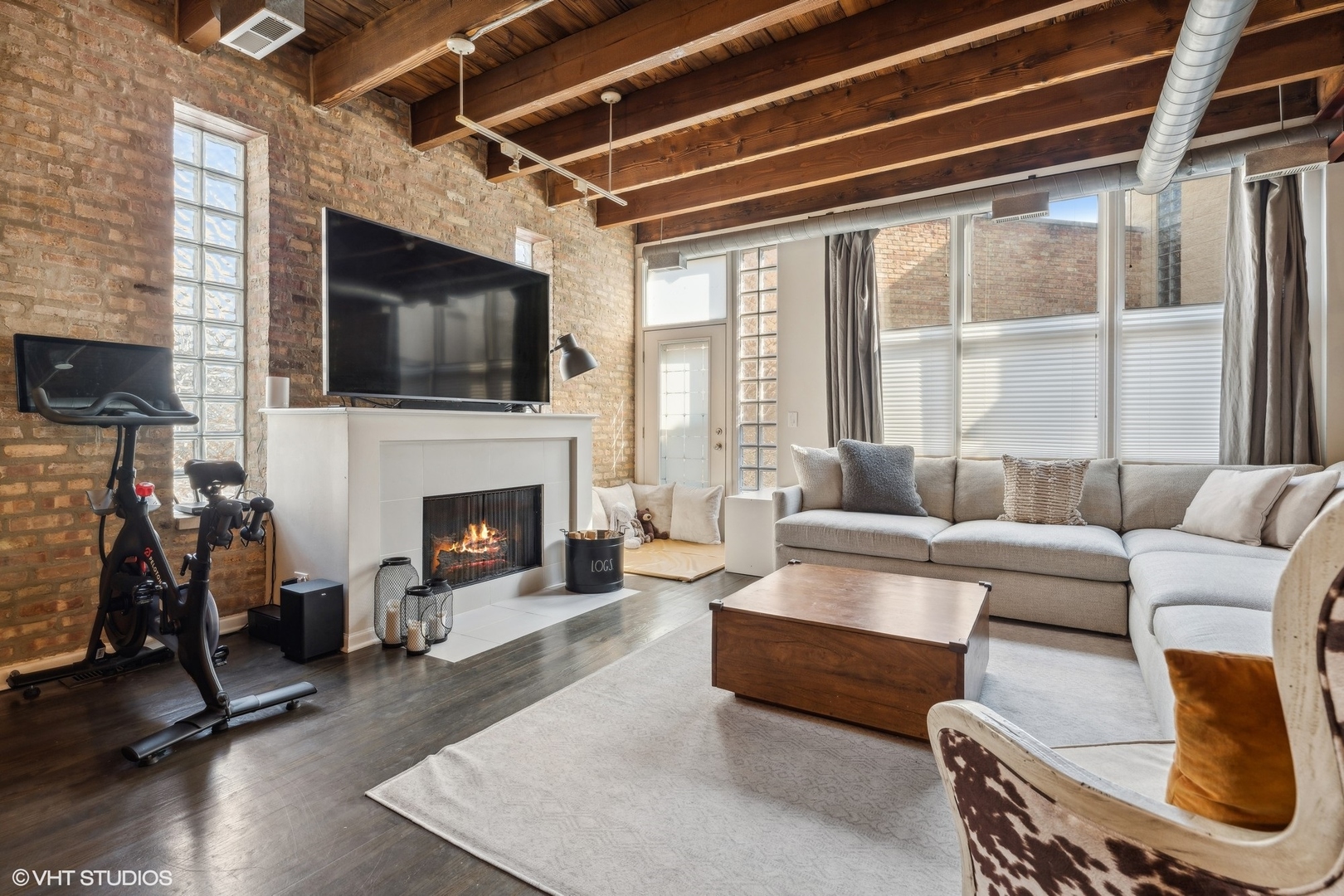 1235 West George Street, Unit 215 Chicago, IL 60657 - Photo 7 of 25 a living room with furniture a flat screen tv and a fireplace