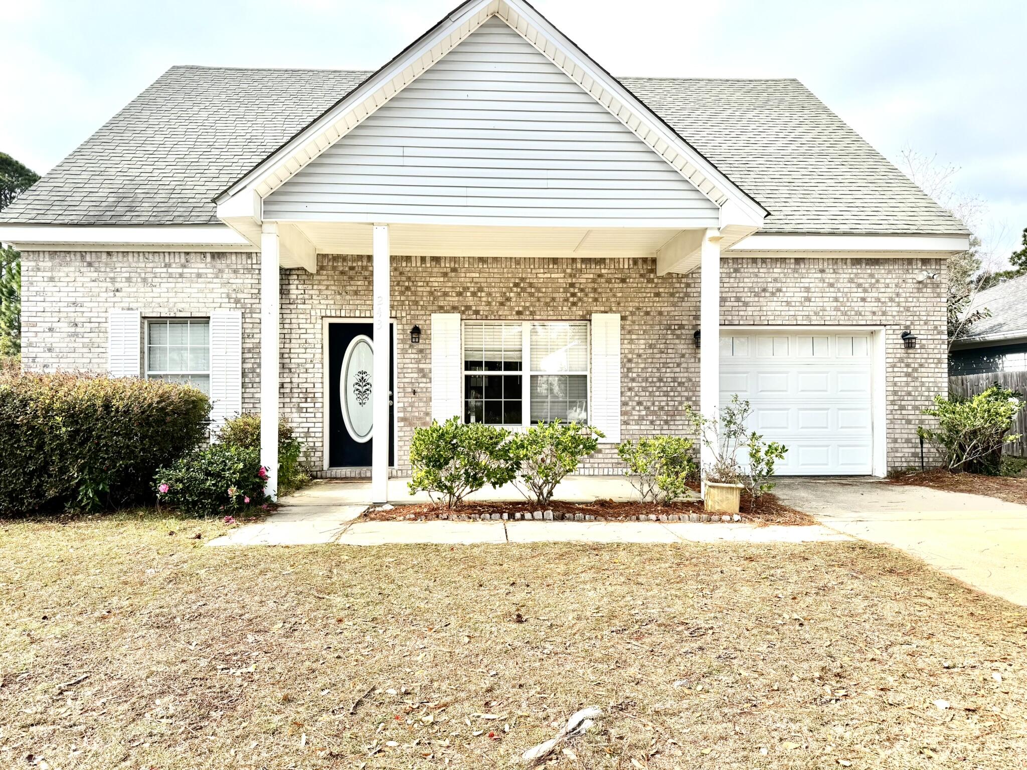 a front view of a house with a yard and potted plants