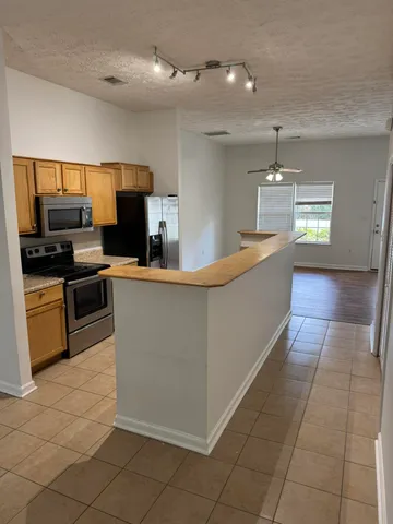 a large kitchen with kitchen island granite countertop a large counter top and stainless steel appliances