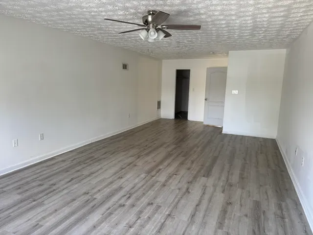 a view of a livingroom with wooden floor and ceiling fan