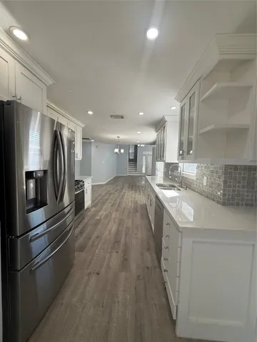a kitchen with granite countertop white cabinets and white stainless steel appliances