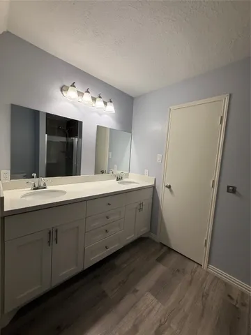 an empty room with wooden floor and mirror