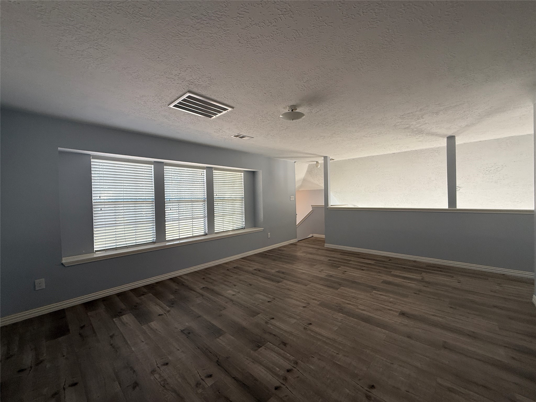 19614 Azalea Valley Drive Katy, TX 77449 - Photo 21 of 27 a view of an empty room with wooden floor and a window