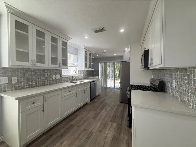 a kitchen with cabinets and stainless steel appliances