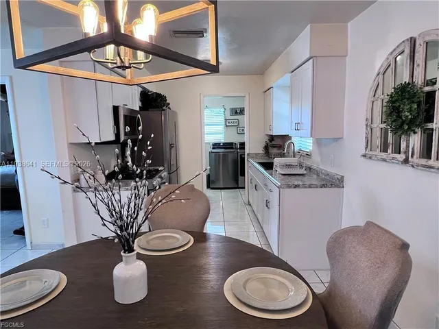 a dining room with furniture potted plants and wooden floor