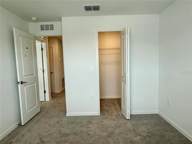 an empty room with closet and a hallway