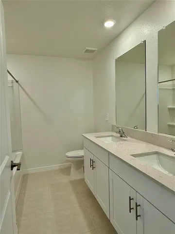 a bathroom with a granite countertop sink a toilet and a mirror