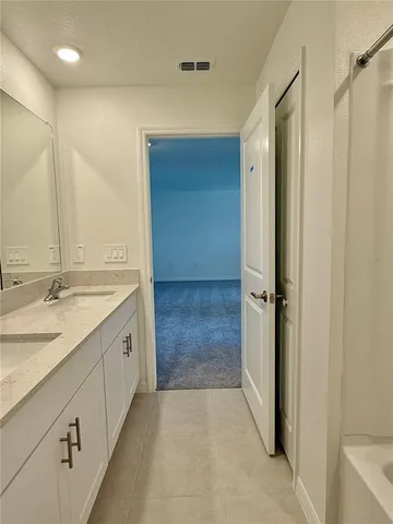 a bathroom with a granite countertop sink mirror and shower