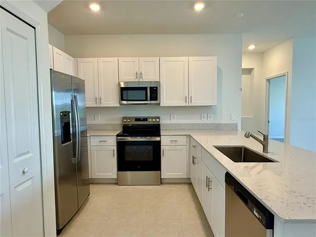a kitchen with stainless steel appliances white cabinets and a sink