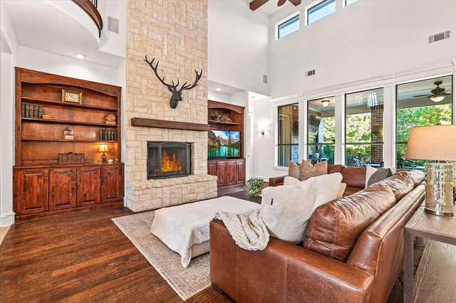 a living room with furniture large window and fireplace
