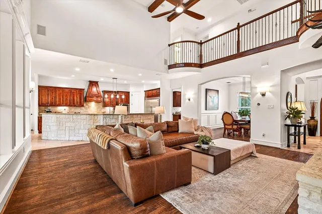 a living room with furniture kitchen view and a wooden floor