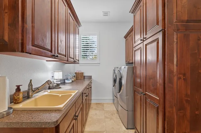 a bathroom with a granite countertop sink and a washing machine