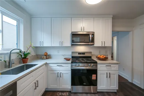 a kitchen with stainless steel appliances a stove a microwave a sink and cabinets