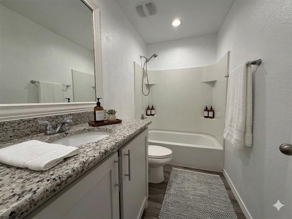 3149 Guyana Road Fort Worth, TX 76123 - Photo 6 of 9 a bathroom with a granite countertop sink a toilet and bathtub