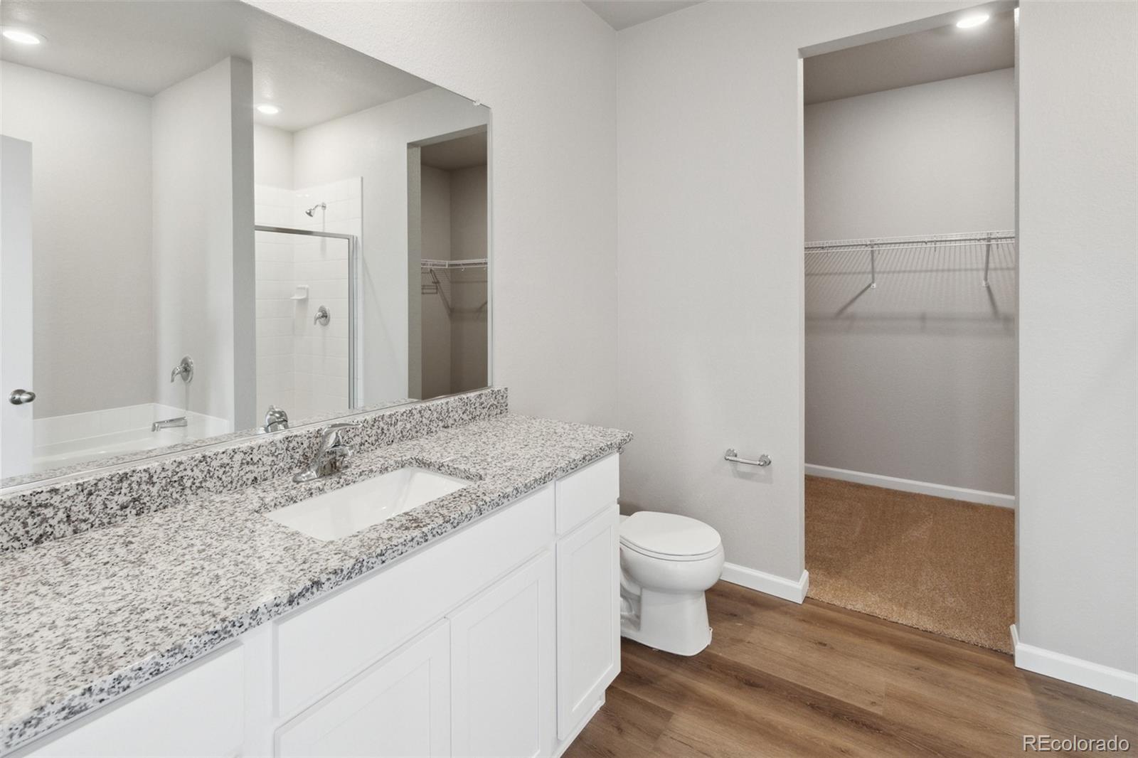 2250 Christina Street Fort Lupton, CO 80621 - Photo 13 of 38 a bathroom with a granite countertop sink a toilet and a mirror
