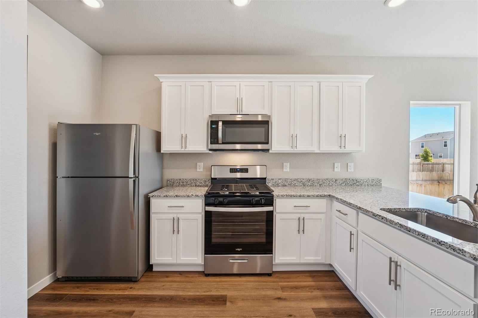 2250 Christina Street Fort Lupton, CO 80621 - Photo 3 of 38 a kitchen with a refrigerator stove and microwave