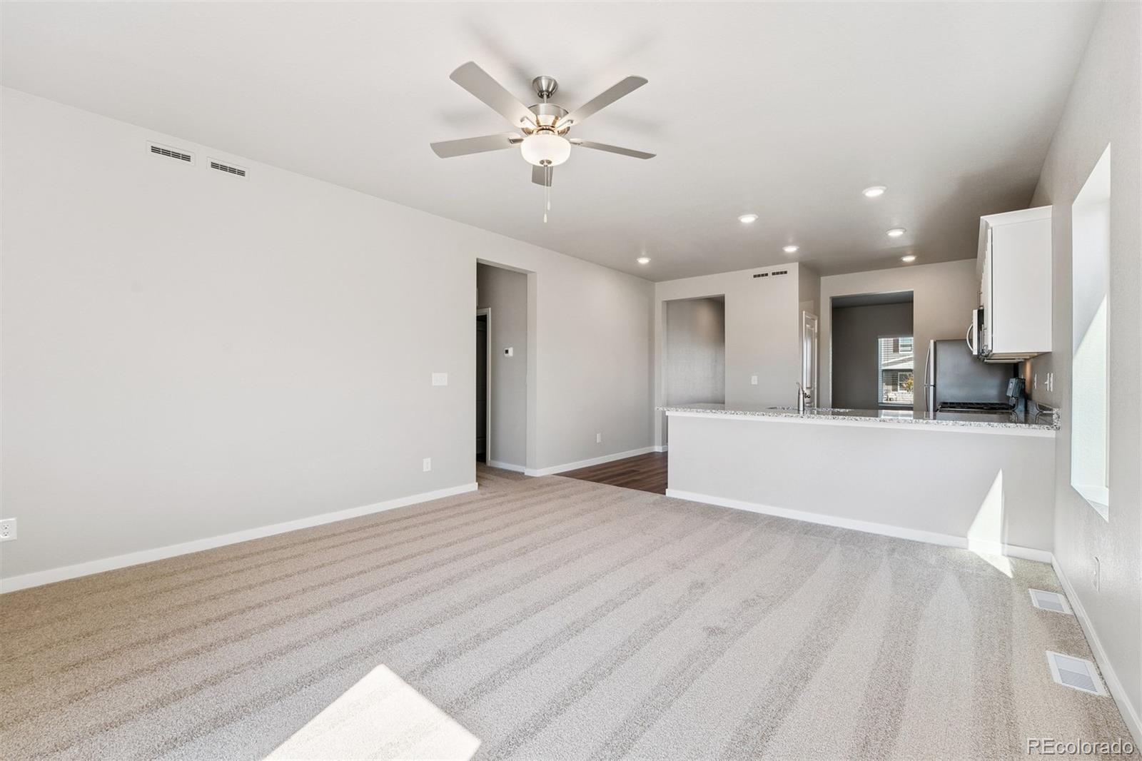2250 Christina Street Fort Lupton, CO 80621 - Photo 7 of 38 a view of an empty room with cabinet and a ceiling fan