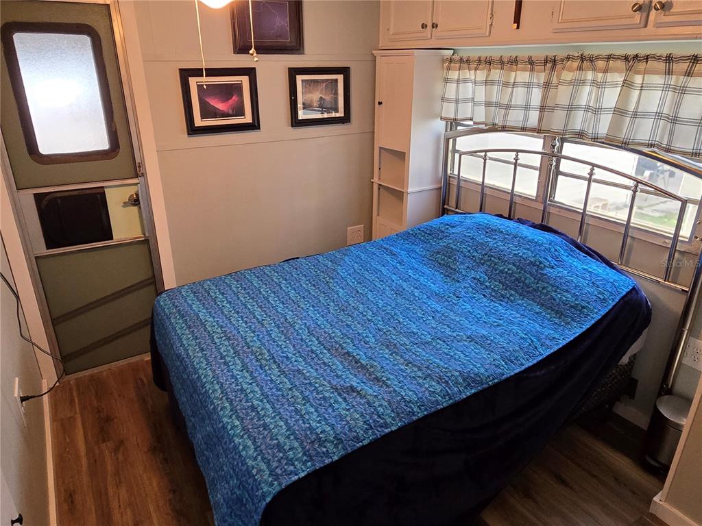 2043 Ketch Circle Palm Harbor, FL 34683 - Photo 28 of 32 a bedroom with a bed and wooden floor