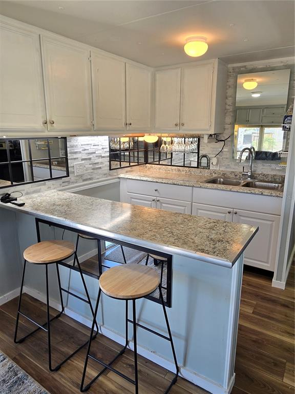 2043 Ketch Circle Palm Harbor, FL 34683 - Photo 6 of 32 a kitchen with stainless steel appliances granite countertop a table chairs in it and wooden floors