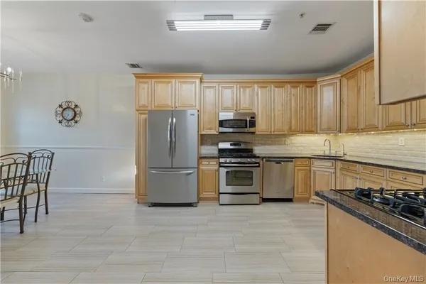 a kitchen with granite countertop a refrigerator stove top oven and sink