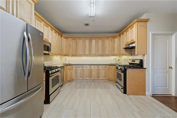 a kitchen with granite countertop a refrigerator stove top oven and sink