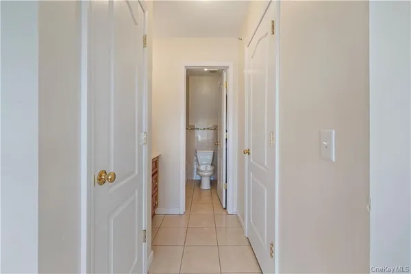 a view of a hallway with closet and wooden door