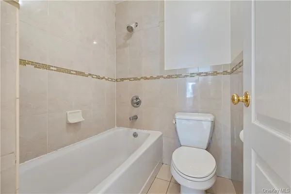 a white toilet sitting next to a bath tub