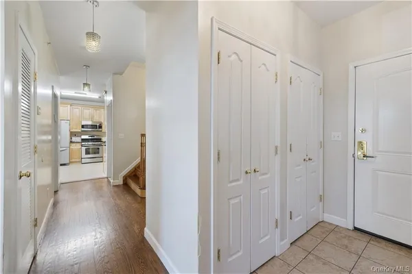 a view of a hallway with wooden floor and a bathroom
