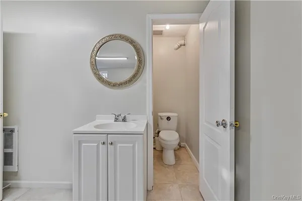 a bathroom with a toilet sink and mirror