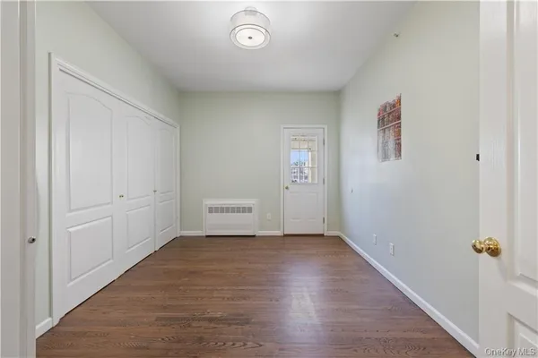 a view of hallway with window and wooden floor