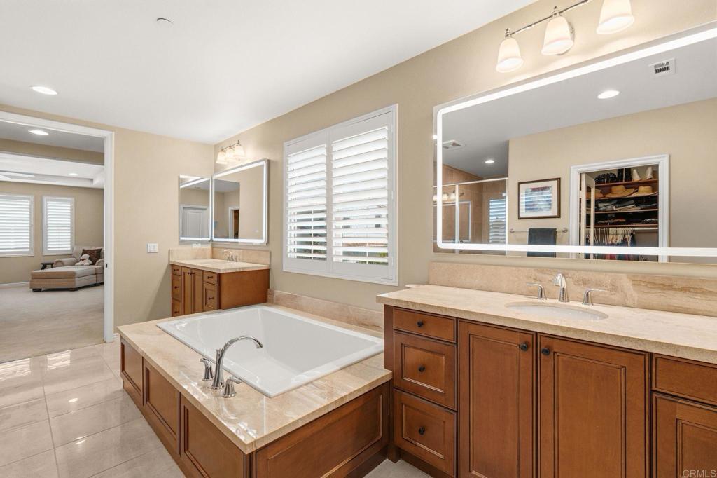 809 Dolphin Circle Encinitas, CA 92024 - Photo 39 of 71 a spacious bathroom with a tub double sink and a large mirror