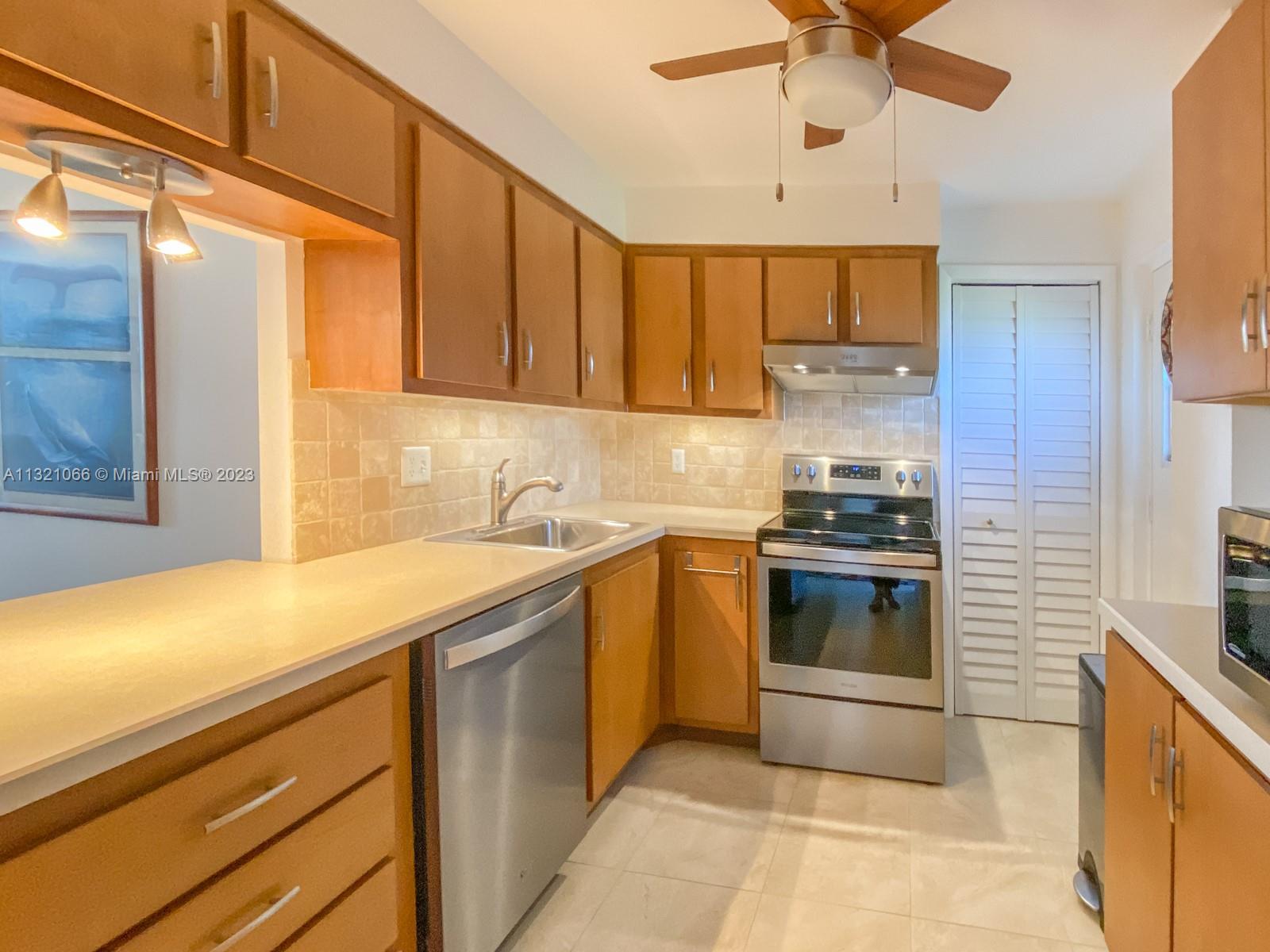 a kitchen with a sink cabinets and stainless steel appliances