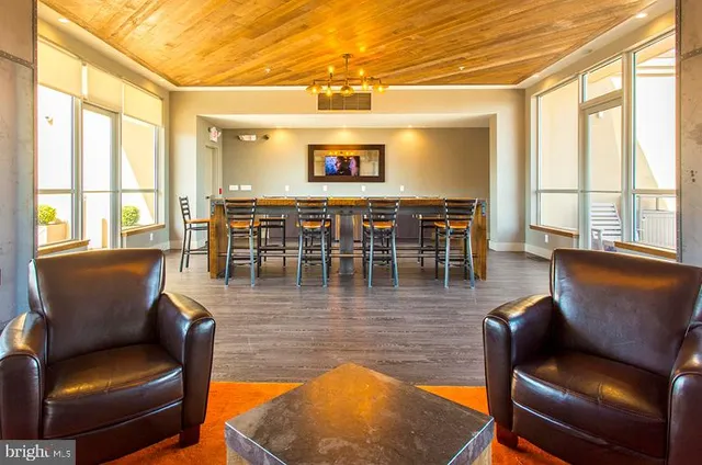 a living room with furniture wooden floor and a floor to ceiling window
