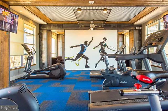 a living room with furniture gym equipment and a large window