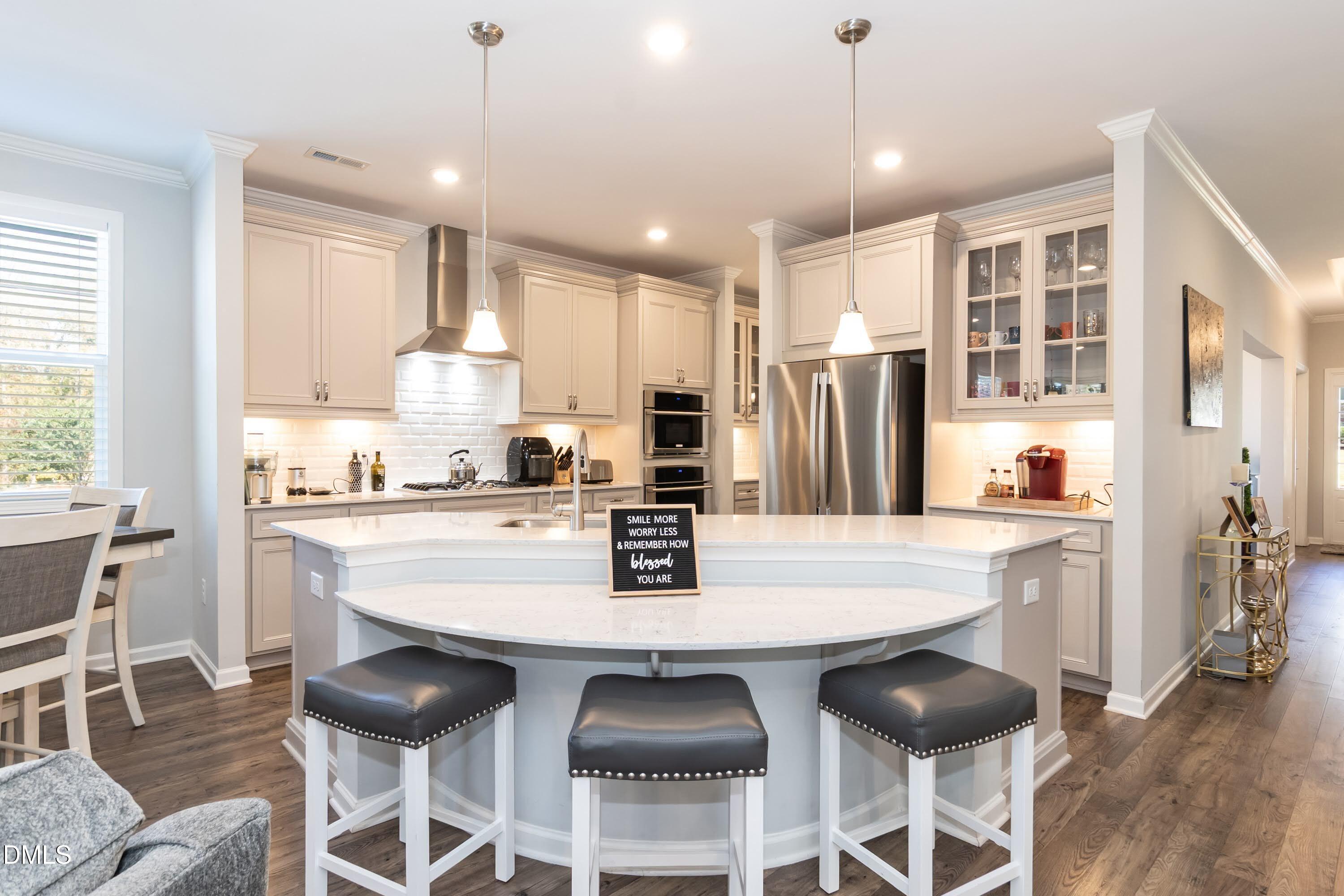 1009 Crescent Moon Court Durham, NC 27712 - Photo 27 of 57 a kitchen with stainless steel appliances granite countertop a dining table chairs refrigerator and microwave