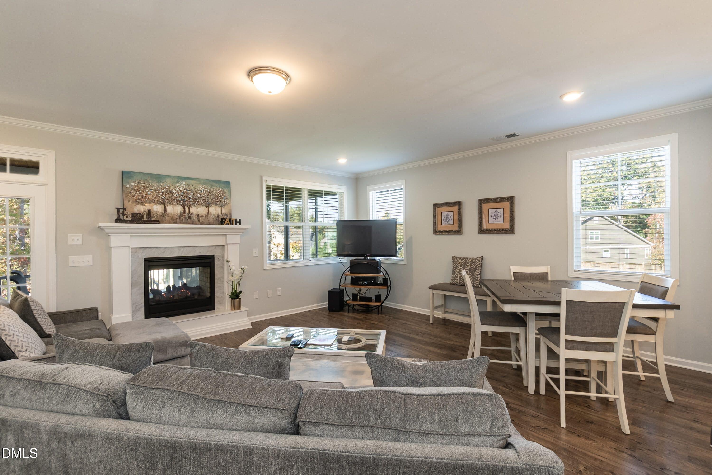 1009 Crescent Moon Court Durham, NC 27712 - Photo 33 of 57 a living room with furniture a fireplace and a flat screen tv