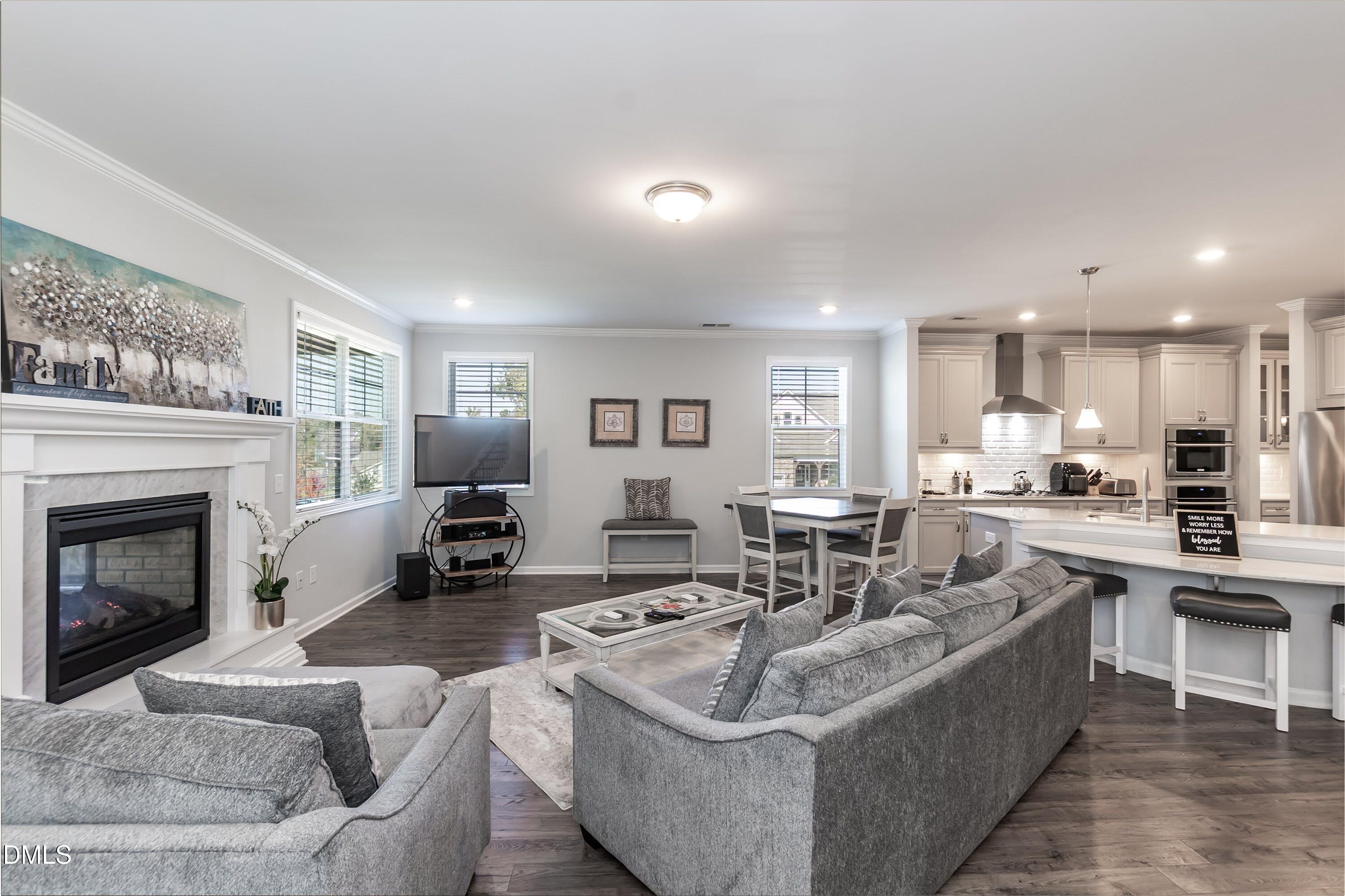 1009 Crescent Moon Court Durham, NC 27712 - Photo 34 of 57 a living room with furniture a fireplace and kitchen view