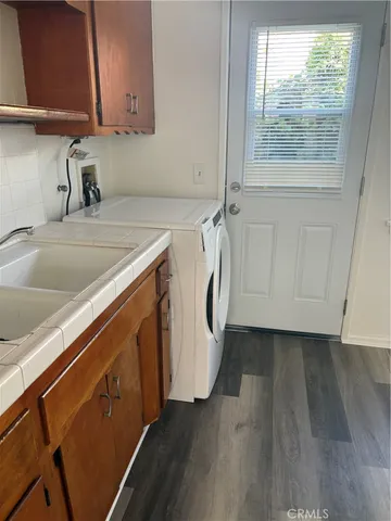 a utility room with wooden floor washer and dryer