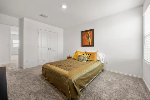 a bedroom with a bed and painting on the wall