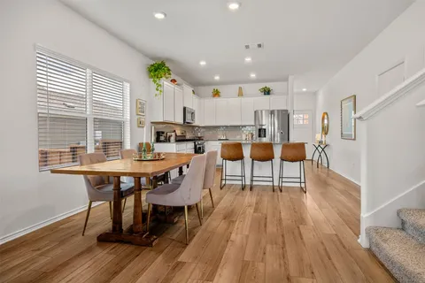 a dining room with stainless steel appliances a table and chairs