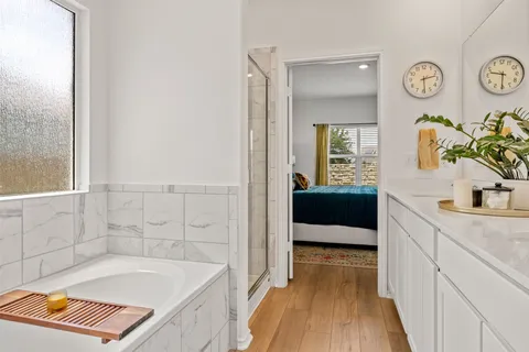 a bathroom with a tub sink and mirror