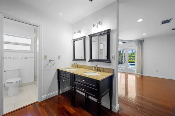a spacious bathroom with a granite countertop sink a toilet and a bathtub