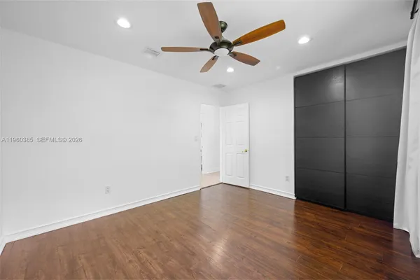 a view of an empty room with wooden floor