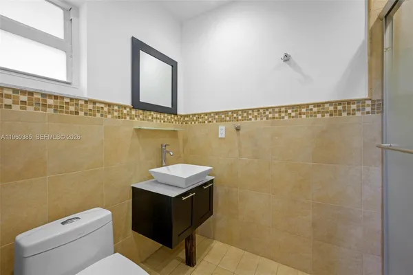 a bathroom with a toilet a sink and mirror