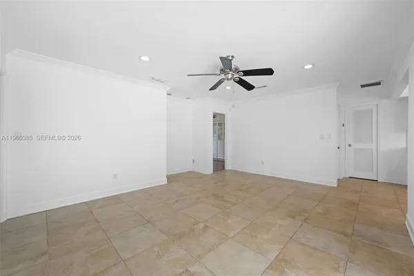 a view of a big room with a ceiling fan and window