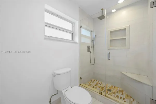 a bathroom with a toilet and a shower
