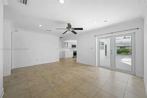 a view of a livingroom with a ceiling fan & entryway
