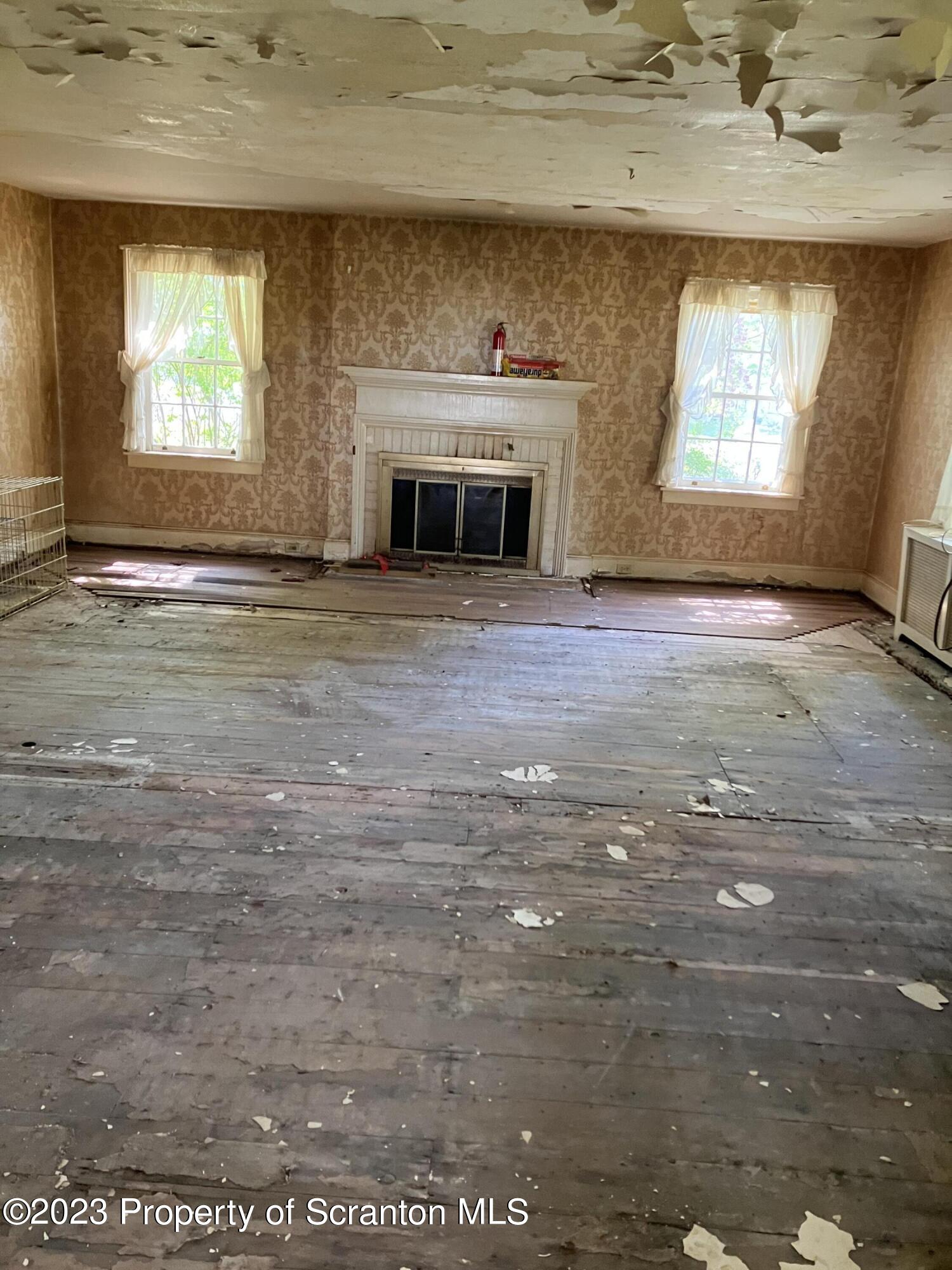 321 Maple Street Montrose, PA 18801 - Photo 19 of 28 an empty room with a fireplace and windows